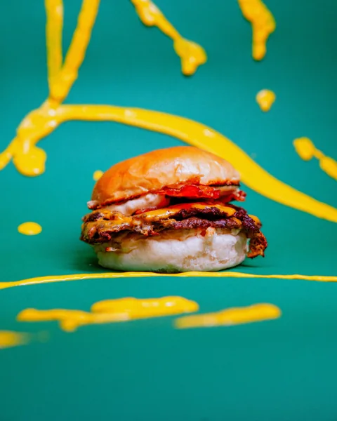 Burger su sfondo verde con schizzi di vernice